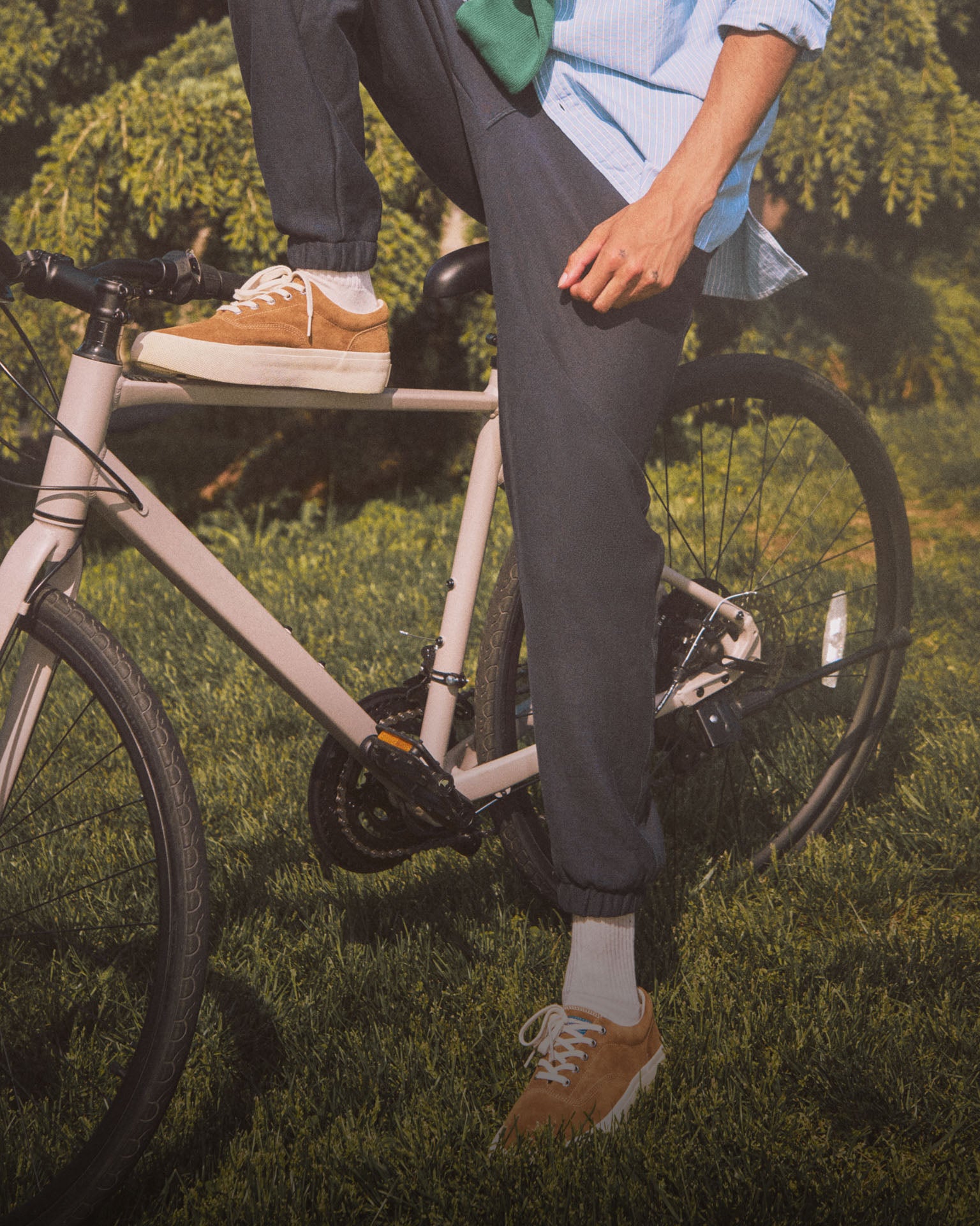A man sitting on a bicycle wearing orange sneakers