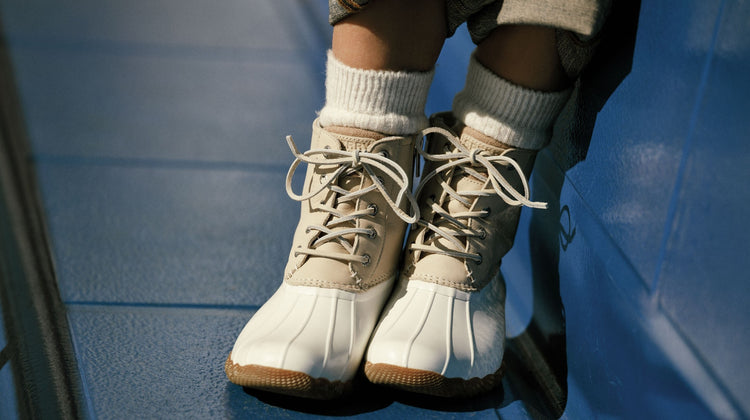A pair of white and beige boots on a blue bench
